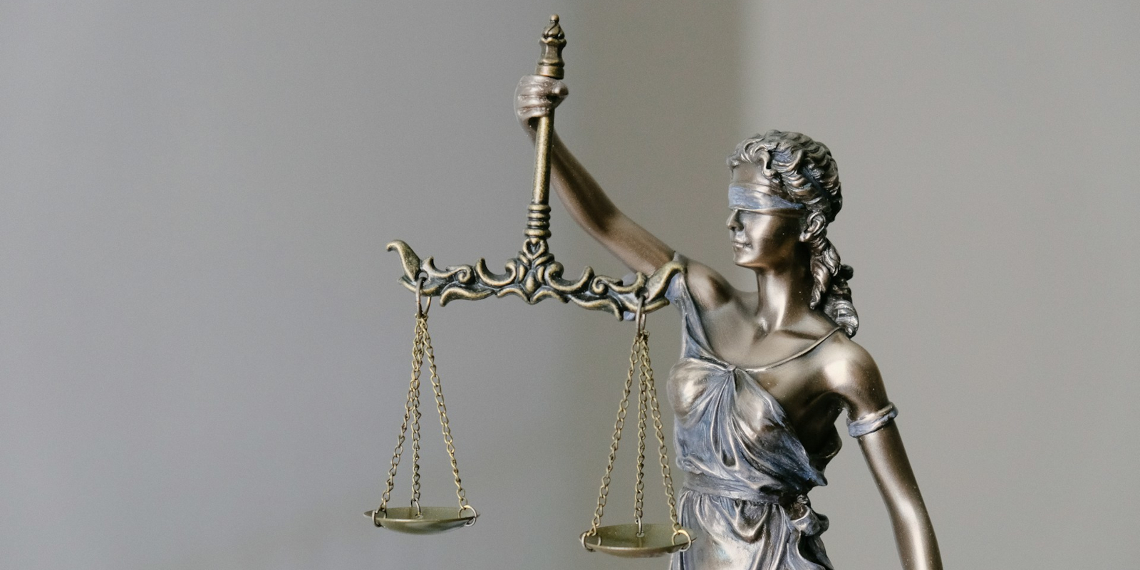 A bronze statue of justice with scales and blindfold