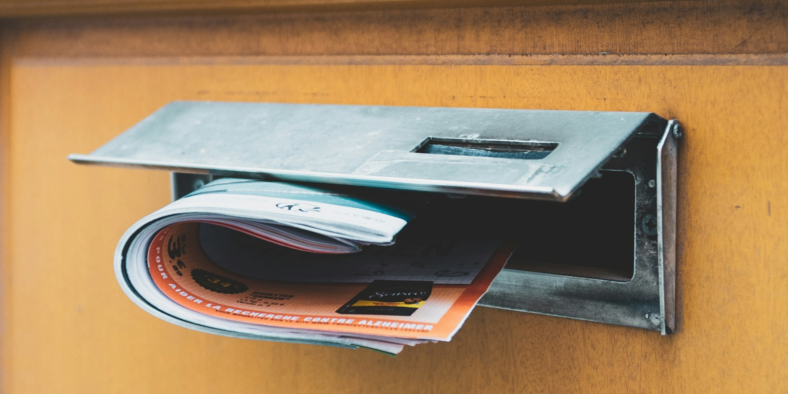 pamphlets pushed through the letterbox of a yellow door