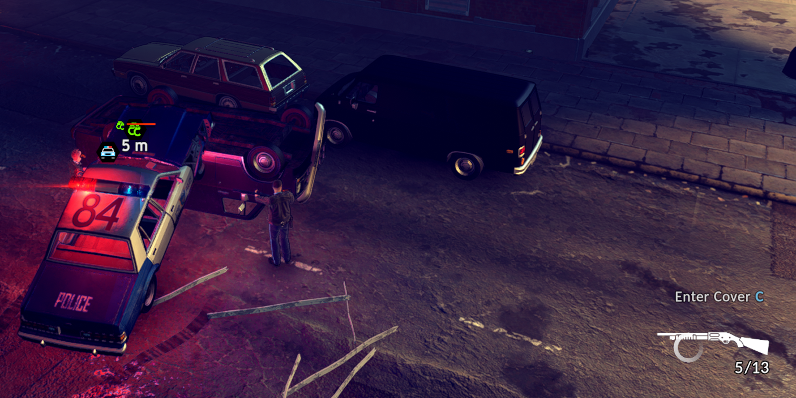 A police car parked atop an upside down vehicle at night