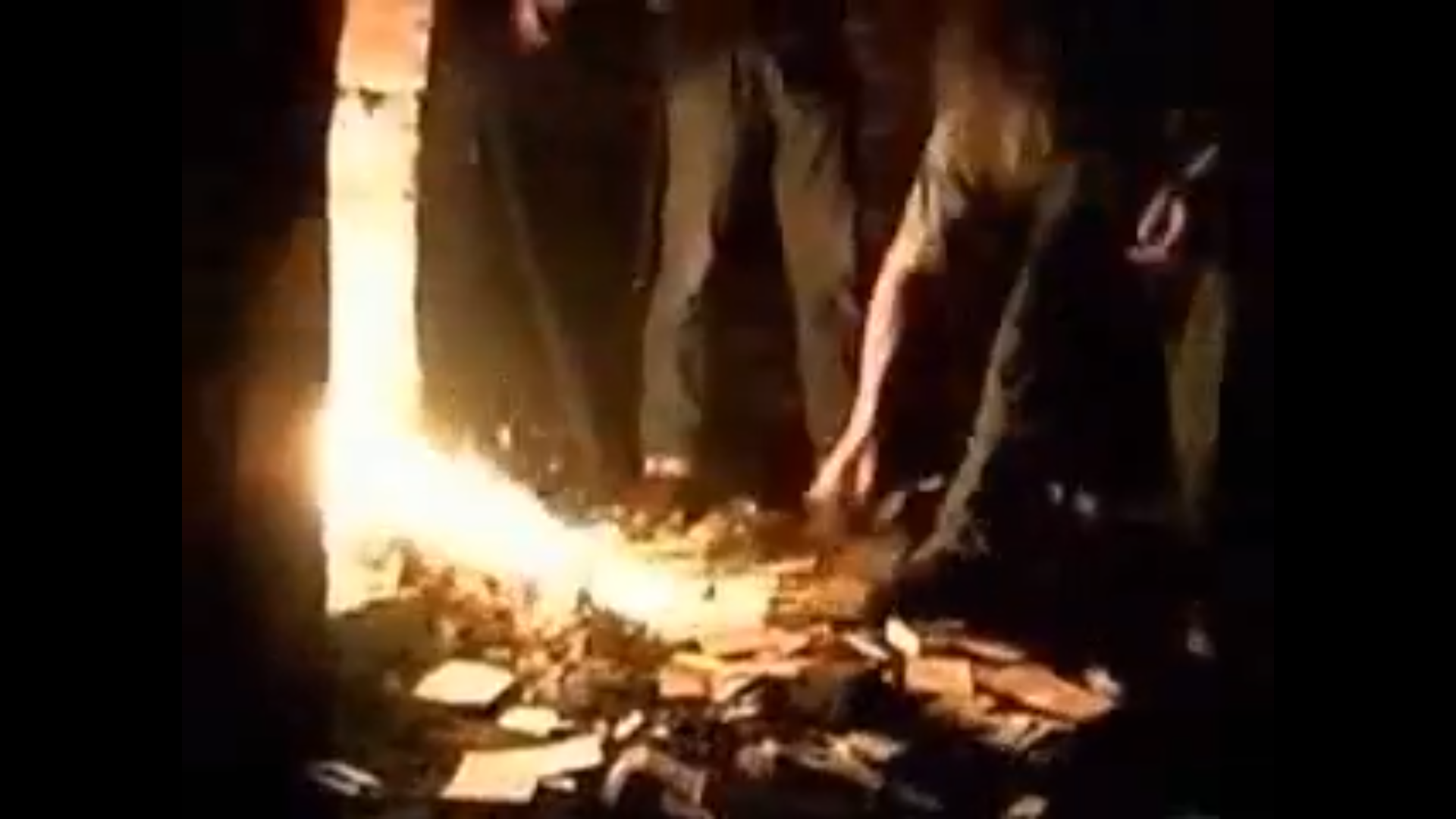 Two men shovelling money into a fire