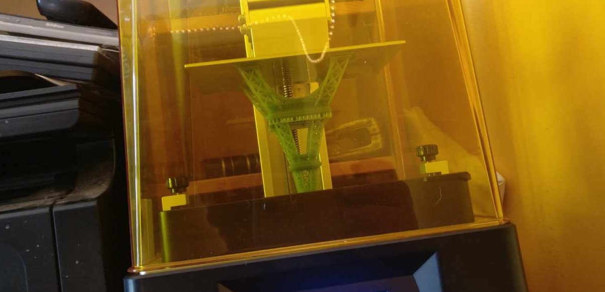 Upside down Eiffel tower emerging from a vat of resin