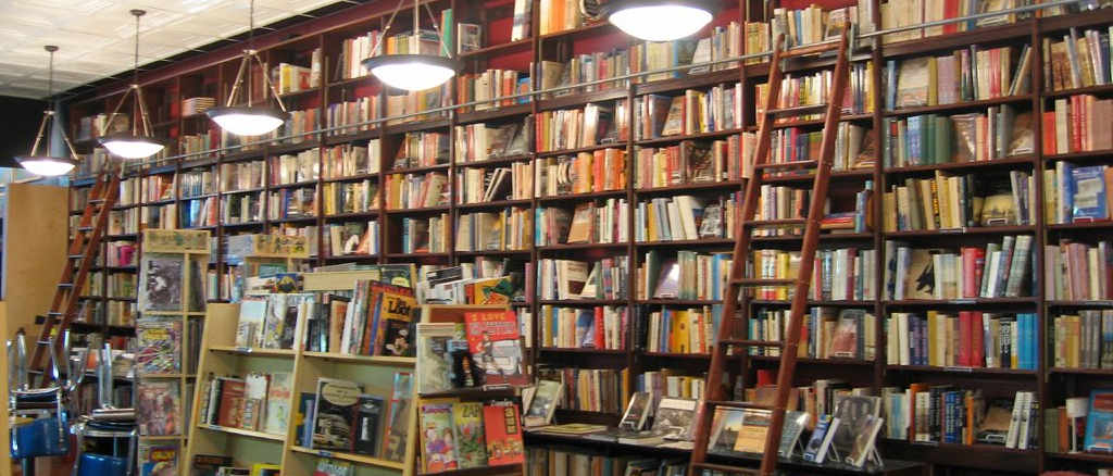 Interior of a bookshop with ladders stacked against the piles