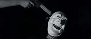 Black and white photo of a masked man  with a gun to his head