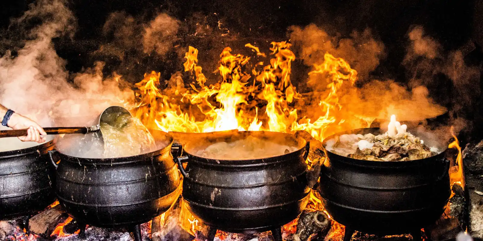 A row of cooking pots on fire