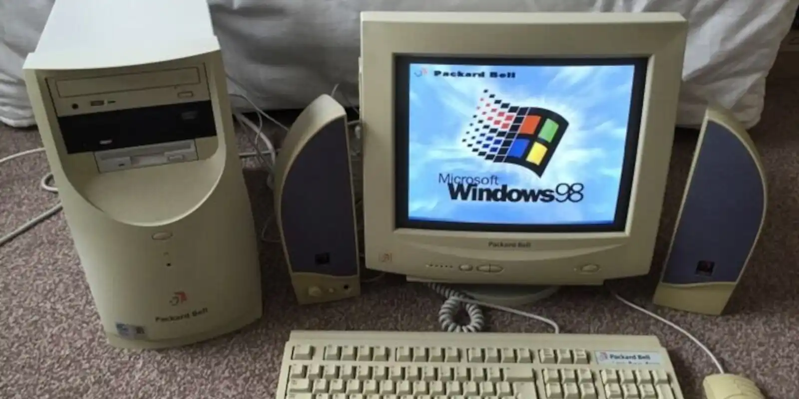 A tower PC and monitor showing the Windows 98 boot screen