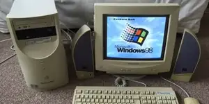A tower PC and monitor showing the Windows 98 boot screen