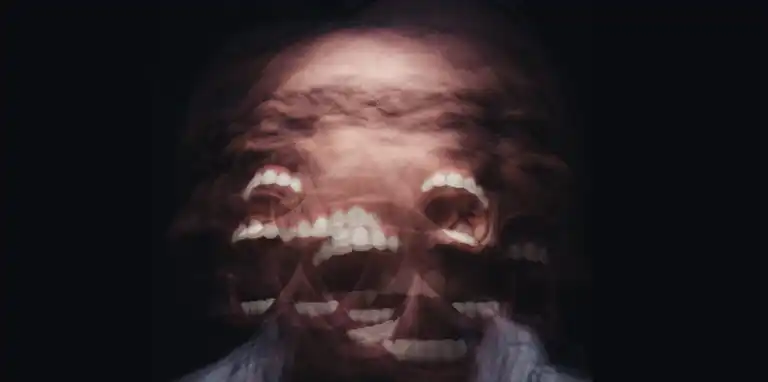 Multiple exposures of a man screaming while shaking his head