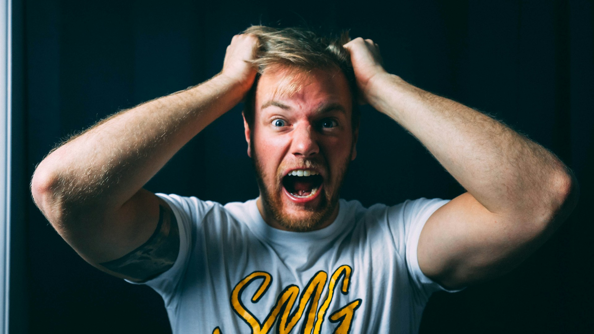 A man holding his hair and screaming