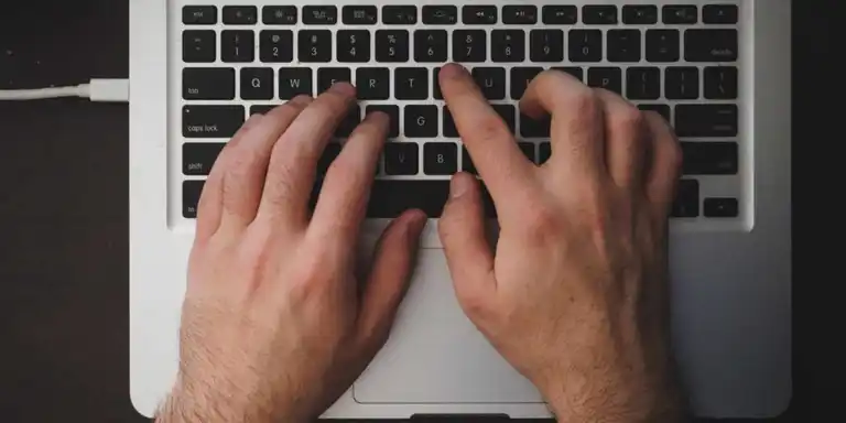 Hands typing on a keyboard