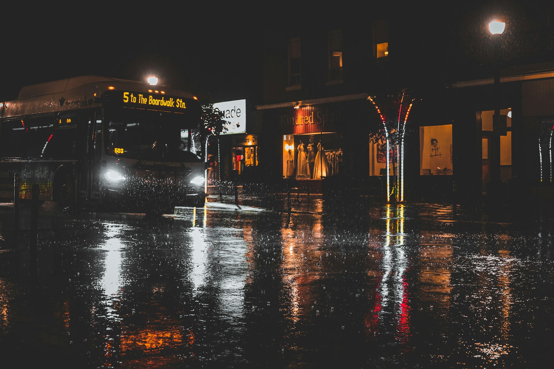 A bus driving through the rain at night