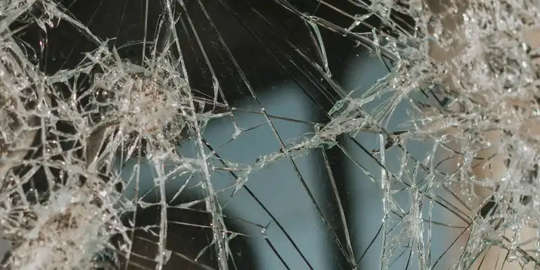 A pane of glass smashed as if hit by a single stone
