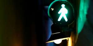 Illuminated pedestrian crossing sign at night