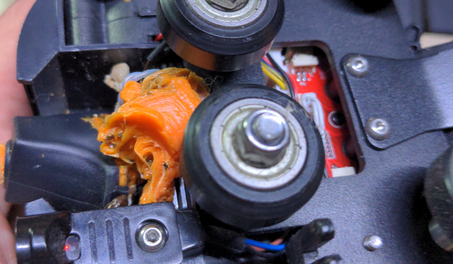 Extruder assembly covered in orange gunk
