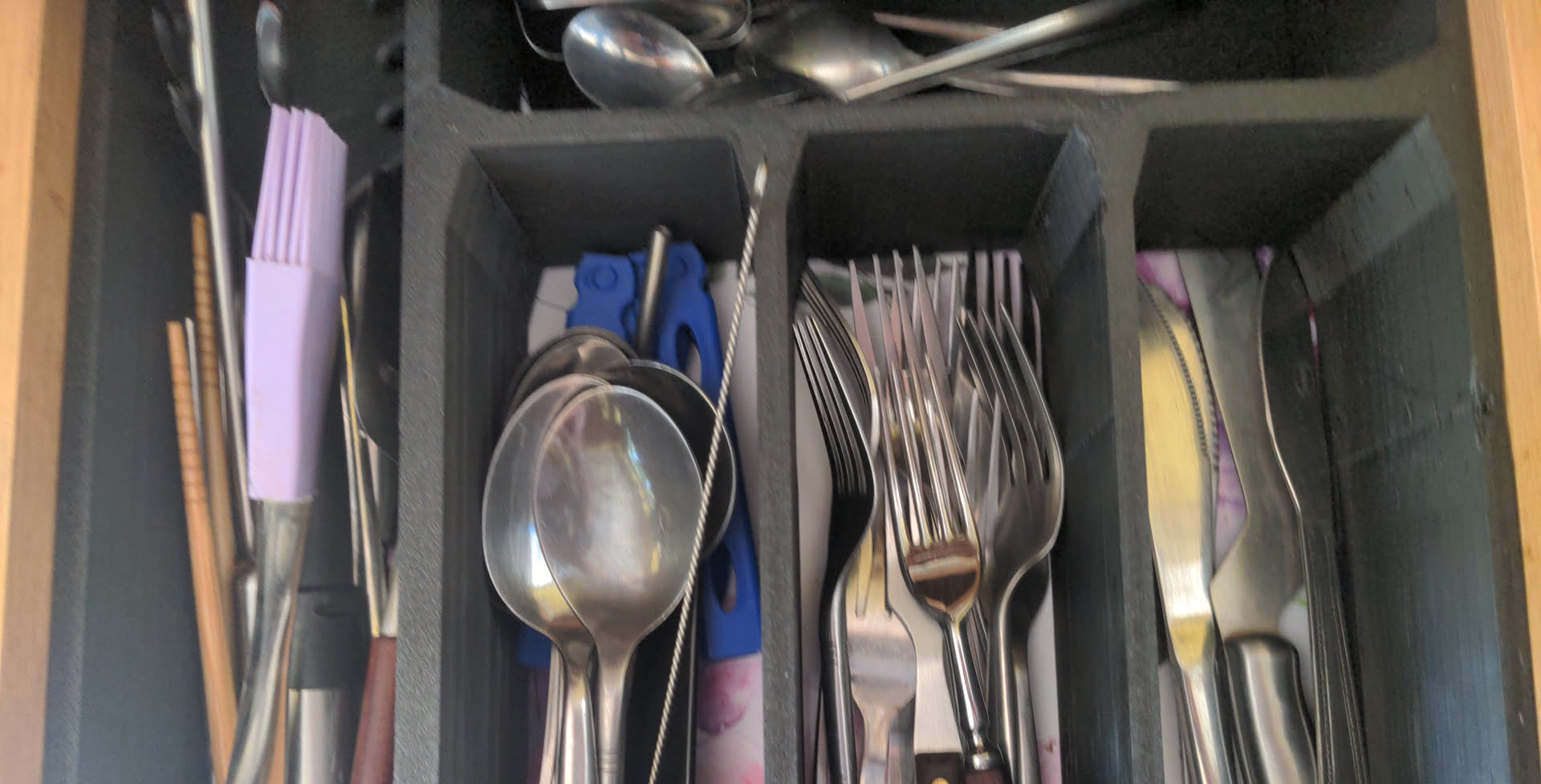 A selection of cutlery in a black 3d printed drawer divider
