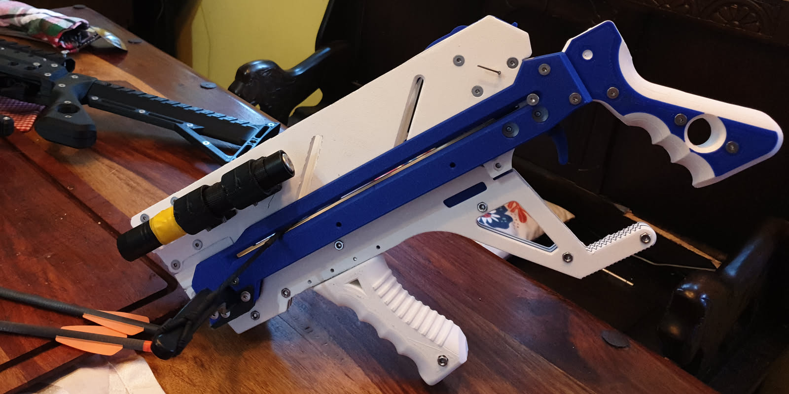 A blue and white repeating crossbow on a table